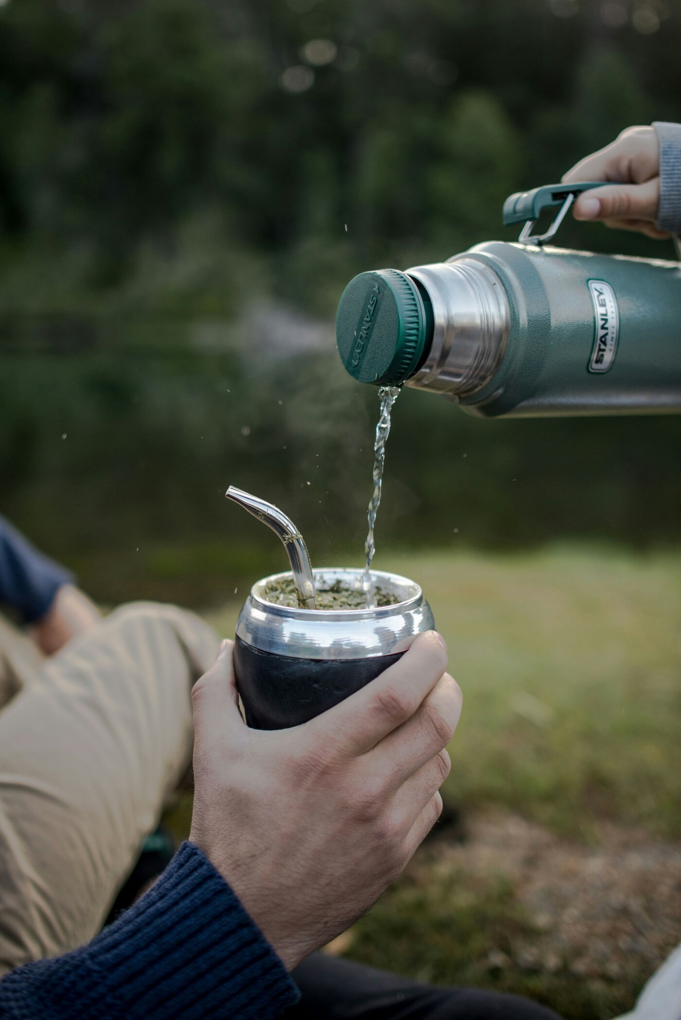 Stainless steel mate cup with bombilla on an outdoor table, gifts for yerba mate lovers